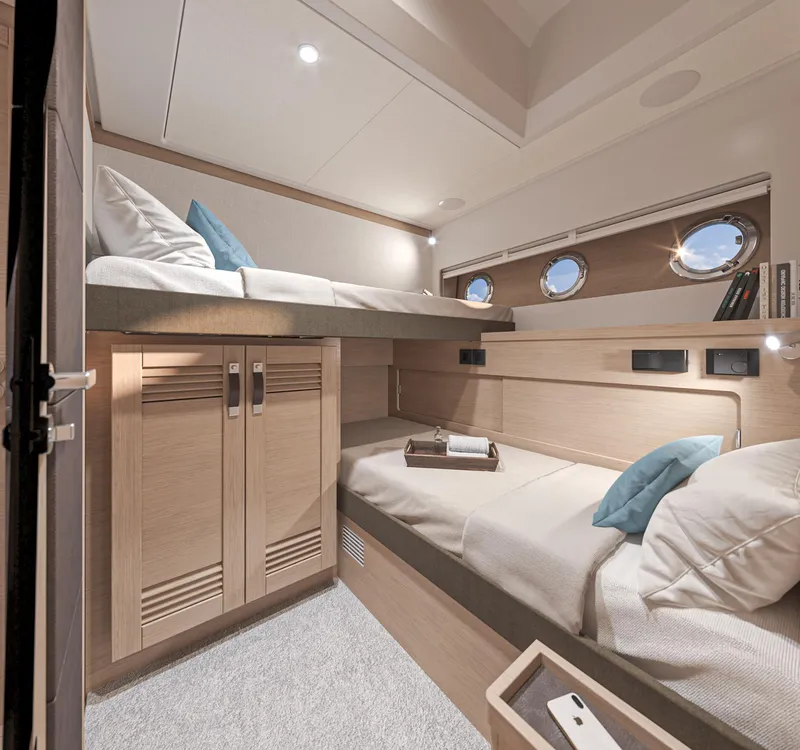 Slide: The Image of Interior cabin of 2025 Beneteau Swift Trawler 54 with bunk beds and portholes. - 19
