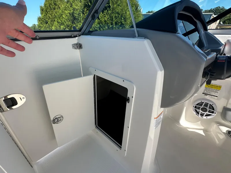 Slide: The Image of 2024 Chaparral 21 SSi OB boat interior storage compartment and dashboard. - 15