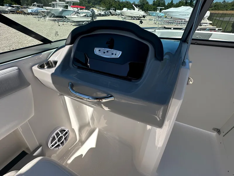 Slide: The Image of 2024 Chaparral 21 SSi OB boat interior, featuring dashboard and storage compartment. - 17
