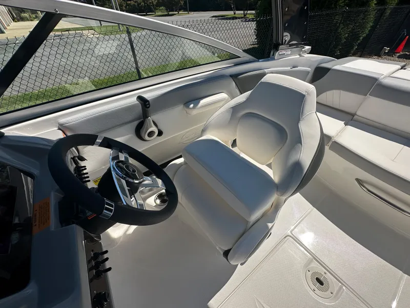 Slide: The Image of 2024 Chaparral 21 SSi OB boat interior with white captain's seat and steering wheel. - 26