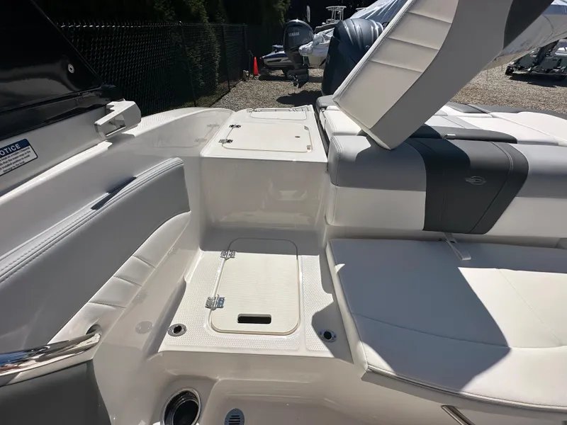 Slide: The Image of 2024 Chaparral 21 SSi OB boat interior with white seating and storage compartments. - 30