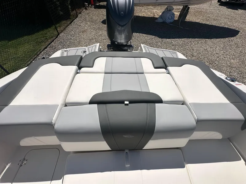 Slide: The Image of 2024 Chaparral 21 SSi OB boat with cushioned seating and outboard motor. - 33