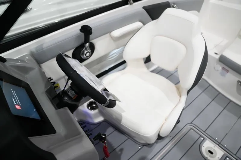 Slide: The Image of Interior of 2025 Chaparral 21 SSi boat featuring a sleek captain's chair and control panel. - 14