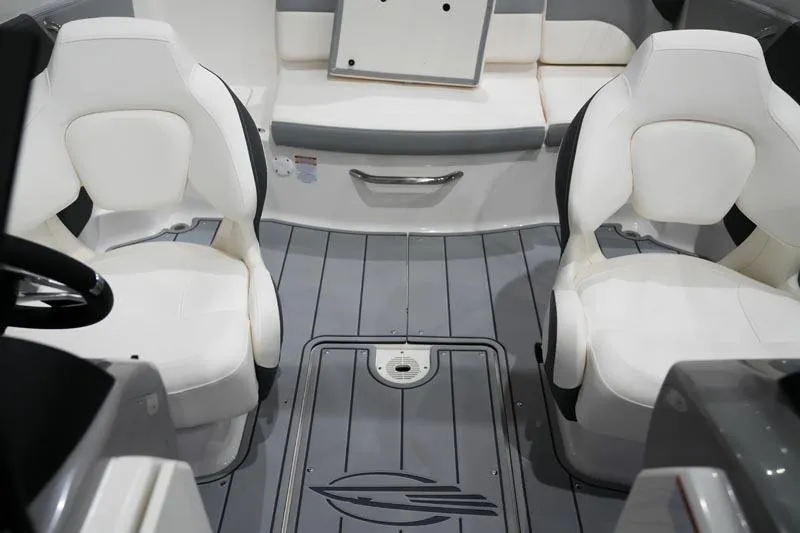 Slide: The Image of 2025 Chaparral 21 SSi boat interior with white seating and gray flooring. - 3