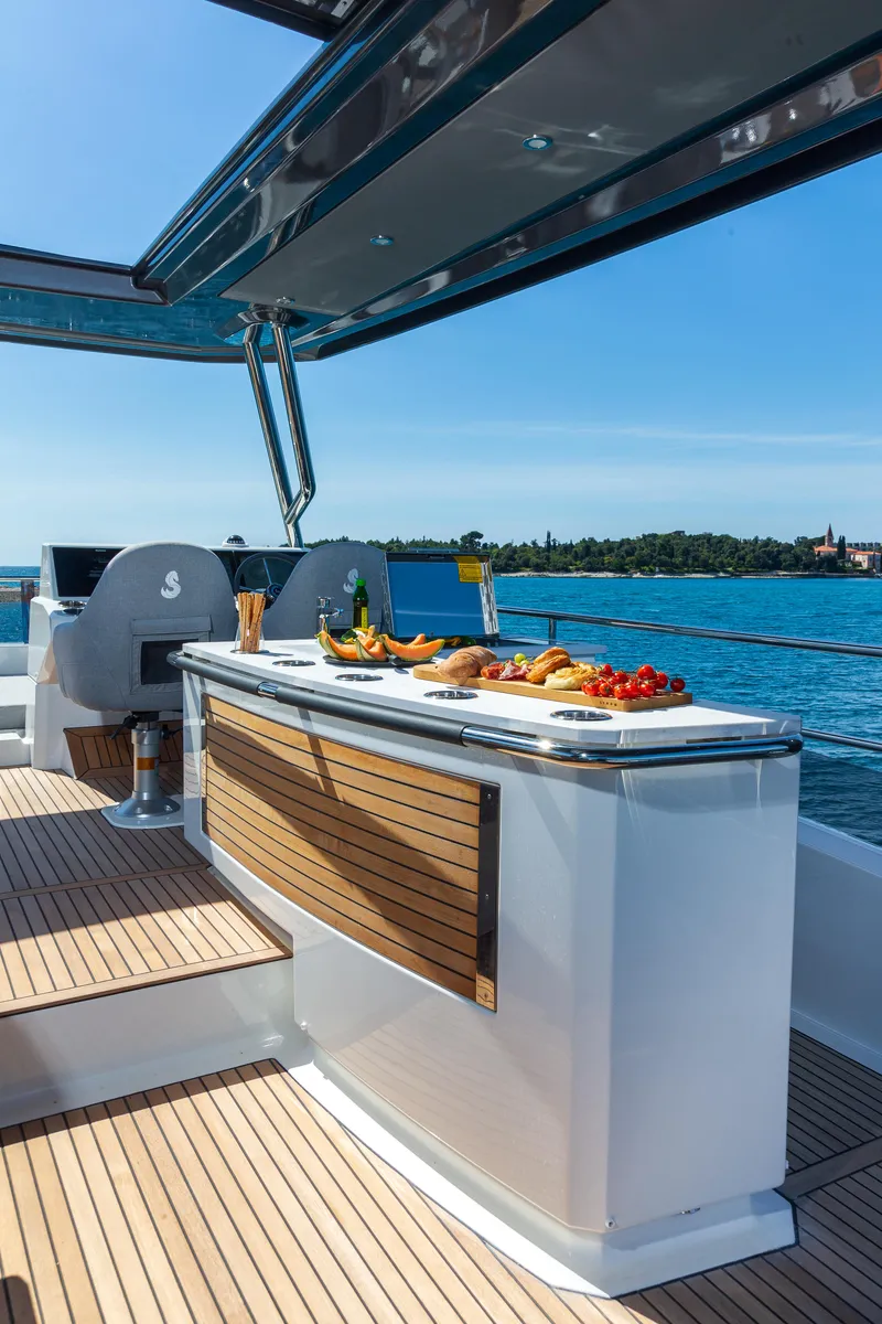 Slide: The Image of Luxurious 2025 Beneteau Grand Trawler 62 yacht with elegant outdoor dining area. - 4