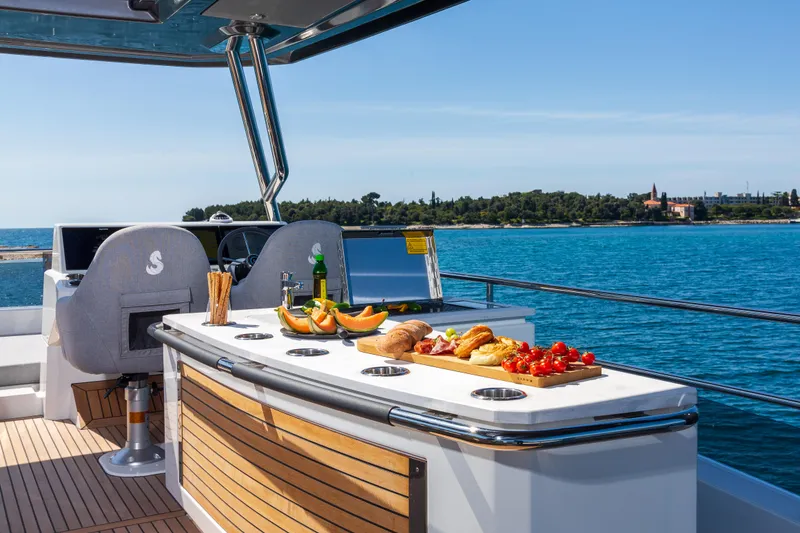 Slide: The Image of Luxurious Beneteau Grand Trawler 62 yacht deck with gourmet spread, 2025 model. - 5