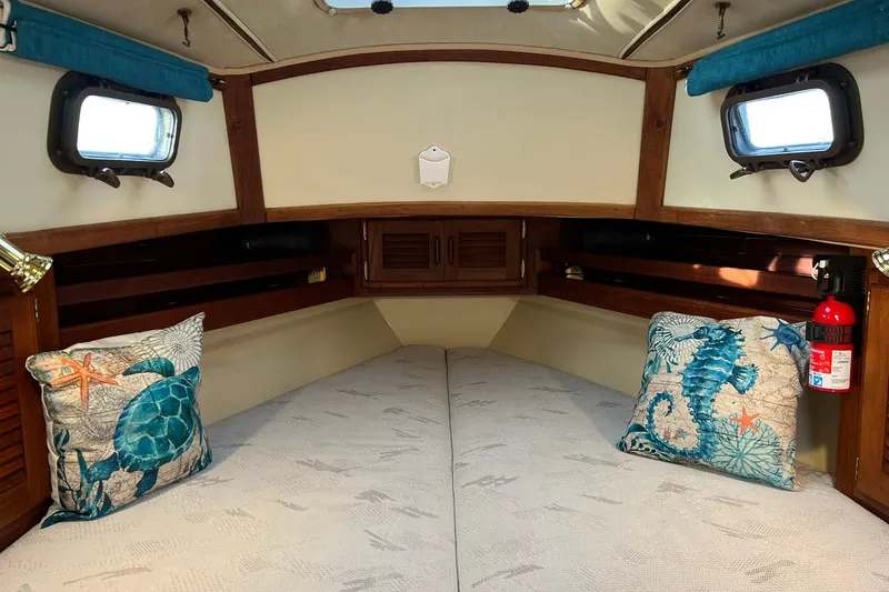 Slide: The Image of Cozy 1994 Pacific Seacraft 31 cabin interior with nautical-themed pillows and wooden accents. - 18