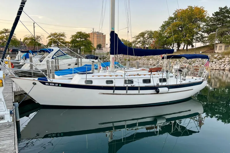 Slide: The Image of 1994 Pacific Seacraft 31 sailboat docked in a marina, surrounded by other boats. - 2
