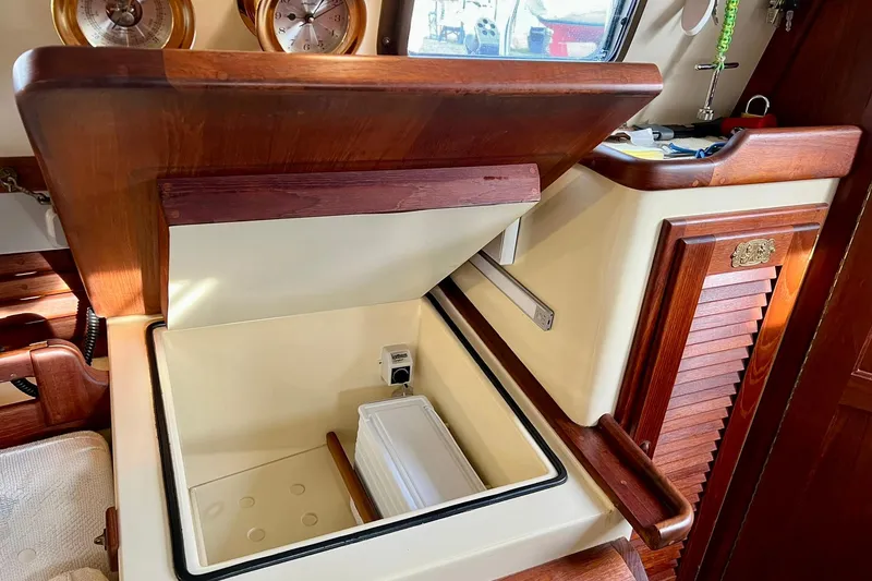 Slide: The Image of 1994 Pacific Seacraft 31 interior with open storage compartment and wooden accents. - 22