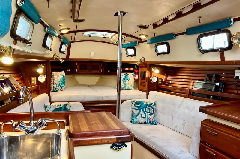 Slide: The Image of Interior of a 1994 Pacific Seacraft 31 sailboat, featuring cozy seating and nautical decor. - 30