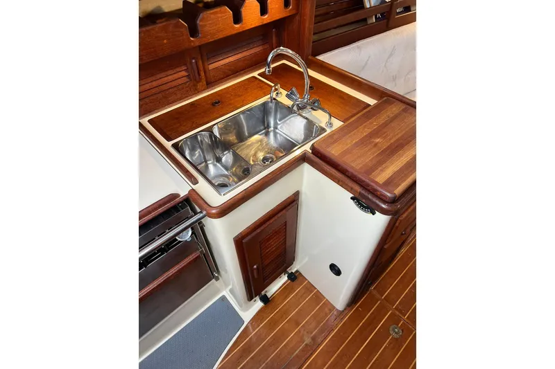 Slide: The Image of 1994 Pacific Seacraft 31 yacht galley with wooden cabinetry and stainless steel sink. - 35
