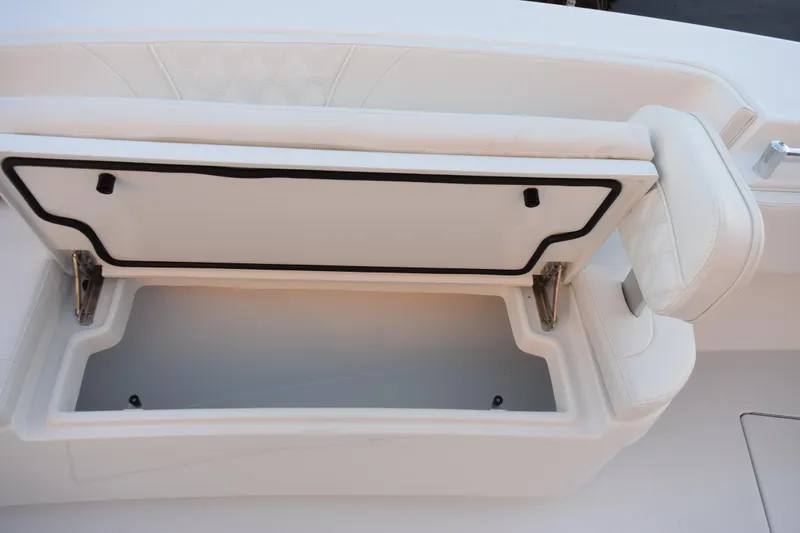 Slide: The Image of Open storage compartment on 2026 Contender 32 ST boat with white cushioned seating. - 16