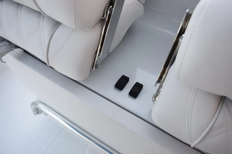 Slide: The Image of 2026 Contender 32 ST boat interior with white cushioned seats and control switches. - 26