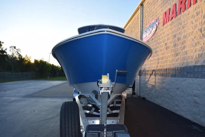 Slide: The Image of 2026 Contender 32 ST boat on trailer, parked beside a marine store. - 3