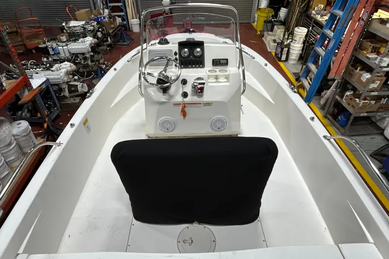 Slide: The Image of 2014 Boston Whaler 18 Dauntless boat interior with steering console in a workshop setting. - 3