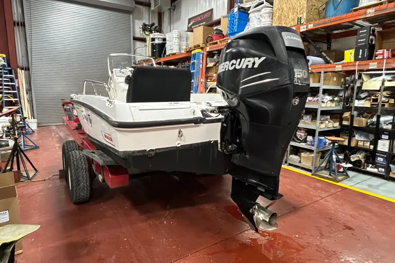 Slide: The Image of 2014 Boston Whaler 18 Dauntless boat with Mercury engine in a workshop setting. - 6