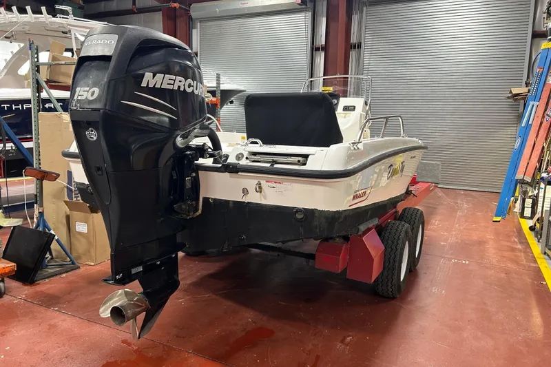 Slide: The Image of 2014 Boston Whaler 18 Dauntless boat with Mercury 150 engine in a garage. - 7