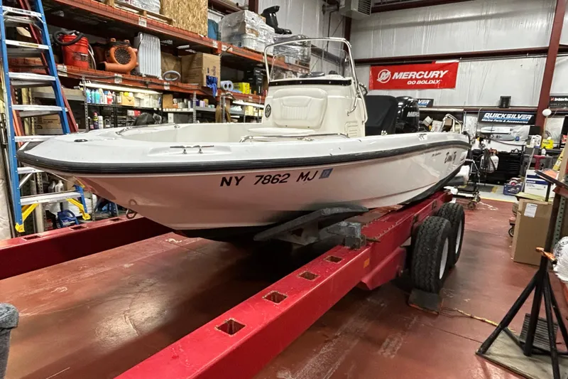 Slide: The Image of 2014 Boston Whaler 18 Dauntless boat on red trailer in a workshop setting. - 8