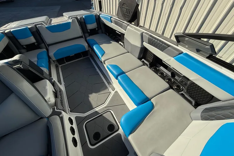 Slide: The Image of 2023 Malibu M240 boat interior with blue and gray seating, showcasing spacious and modern design. - 16