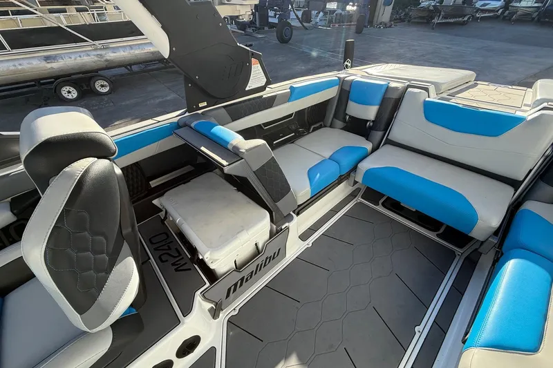 Slide: The Image of 2023 Malibu M240 boat interior with blue and gray seating, showcasing modern design. - 17