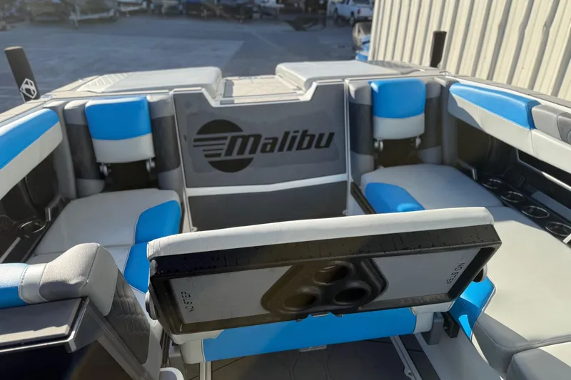 Slide: The Image of 2023 Malibu M240 boat interior with blue and gray seating, showcasing luxury design. - 25