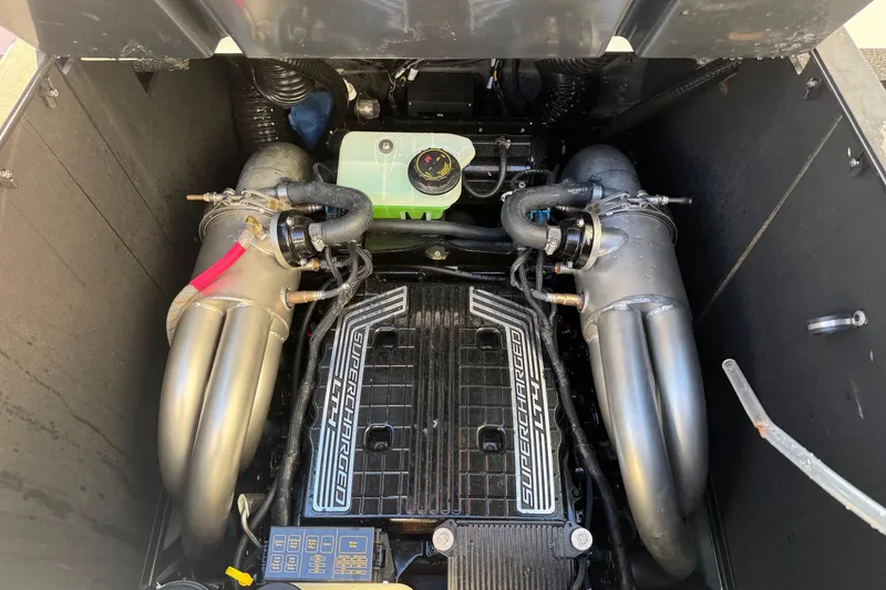 Slide: The Image of 2023 Malibu M240 engine compartment with supercharged engine components and dual exhaust pipes. - 32