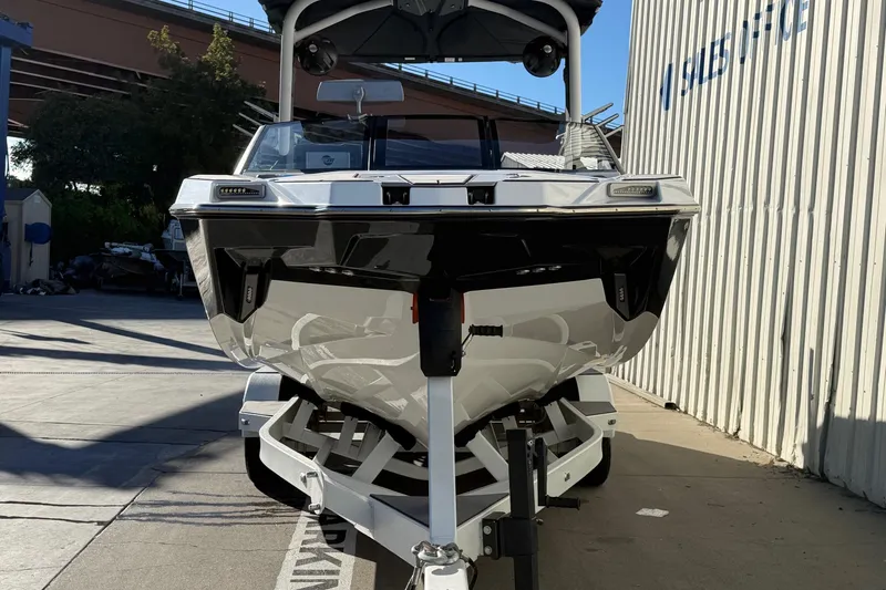 Slide: The Image of 2023 Malibu M240 boat parked outside a sales office, showcasing sleek design. - 4