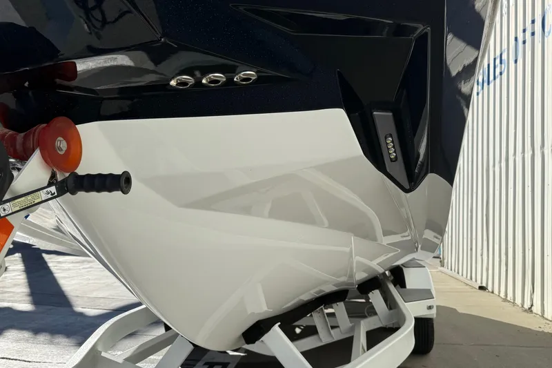 Slide: The Image of 2023 Malibu M240 boat on trailer, showcasing sleek hull design and modern features. - 5