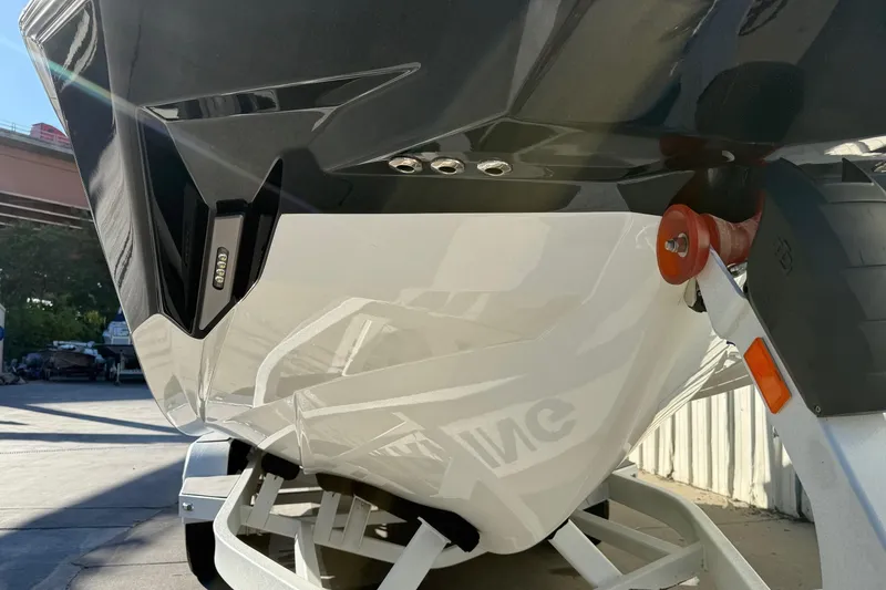 Slide: The Image of 2023 Malibu M240 boat on trailer, close-up of hull and trailer details. - 6