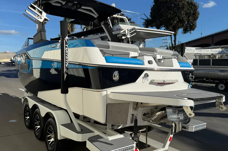 Slide: The Image of 2023 Malibu M240 boat with sleek design on a trailer at a marina. - 8