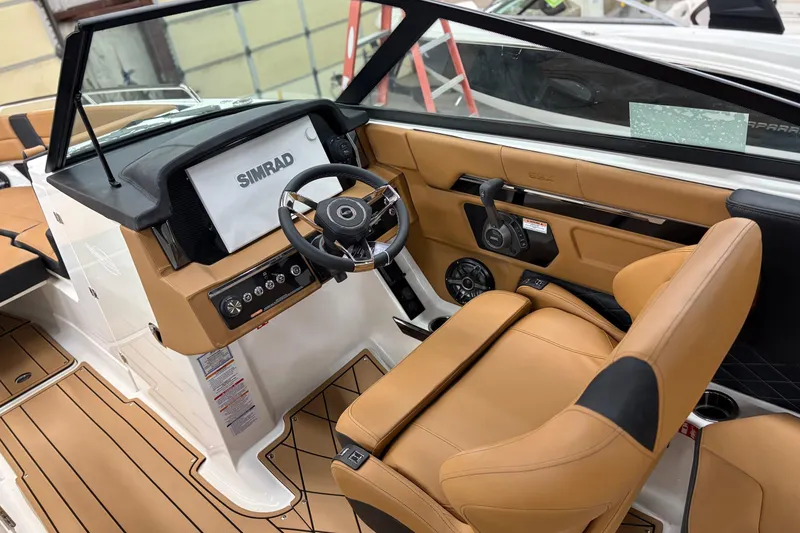 Slide: The Image of 2026 Chaparral 30 SSX boat interior with tan leather seats and Simrad navigation system. - 10
