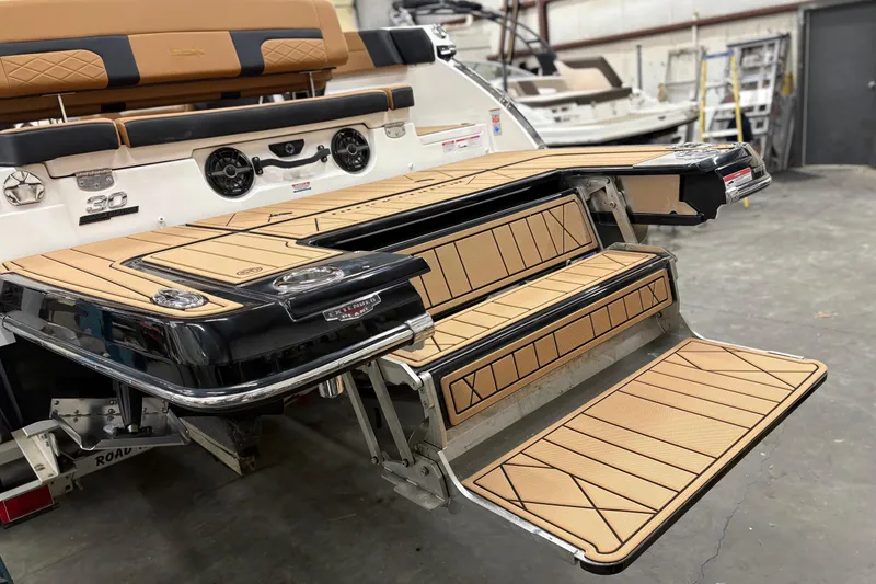 Slide: The Image of 2026 Chaparral 30 SSX boat with tan deck and swim platform in a workshop. - 4