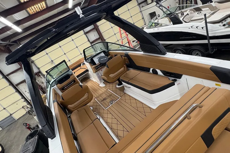 Slide: The Image of 2026 Chaparral 30 SSX boat interior with tan seating and modern design in a showroom. - 5