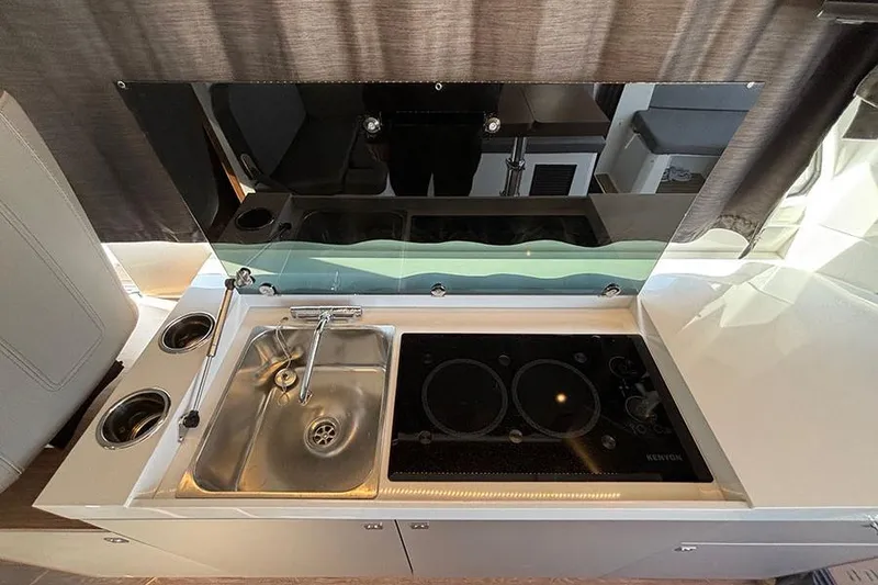 Slide: The Image of 2023 Beneteau Antares 11 kitchen area with sink and stove. - 17