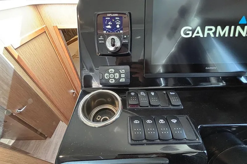 Slide: The Image of Control panel of 2023 Beneteau Antares 11 with Garmin display and switches. - 23