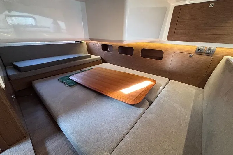 Slide: The Image of Interior of 2023 Beneteau Antares 11, featuring cozy seating and wooden table. - 28