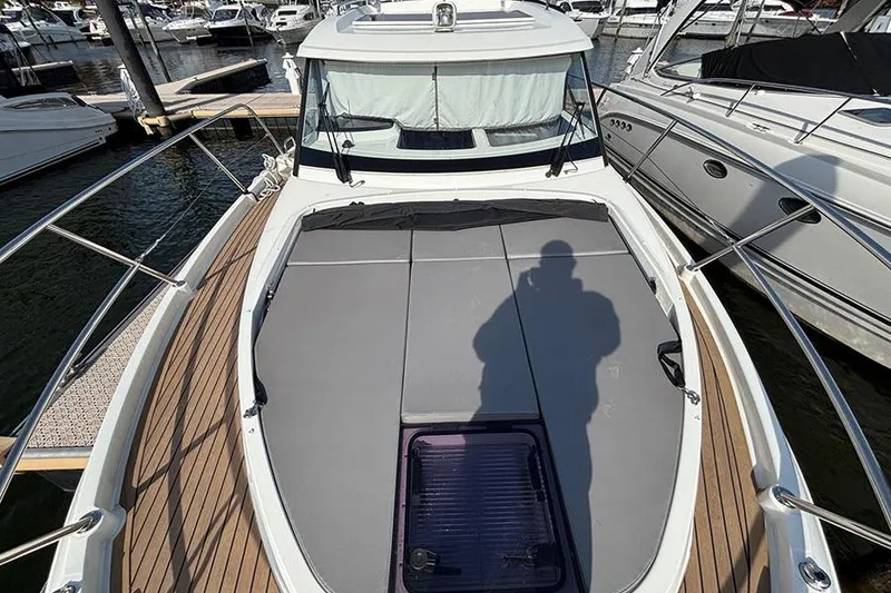 Slide: The Image of 2023 Beneteau Antares 11 boat deck with sunbathing area, docked at marina. - 3