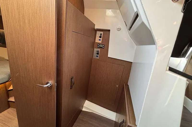 Slide: The Image of Interior view of 2023 Beneteau Antares 11, featuring wooden cabinetry and control panels. - 30