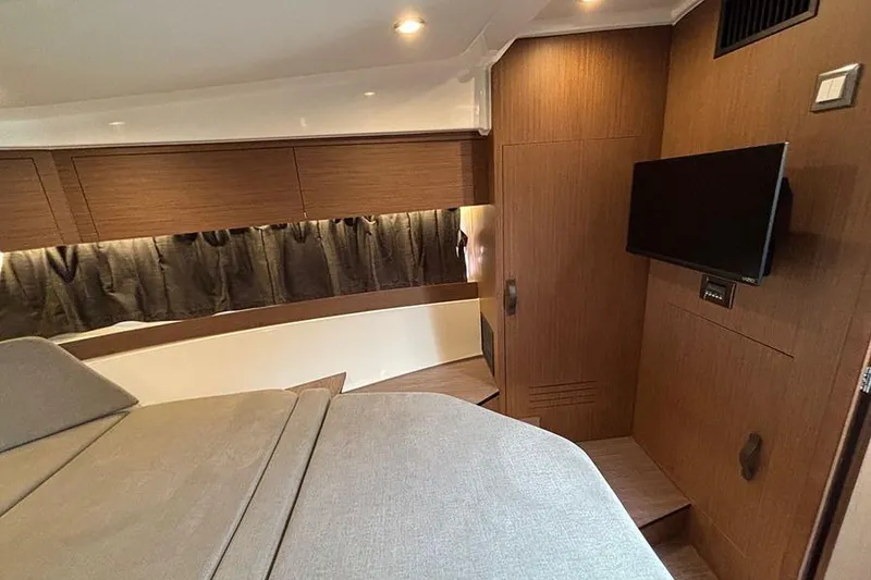 Slide: The Image of 2023 Beneteau Antares 11 cabin interior with modern wood finish and mounted TV. - 32