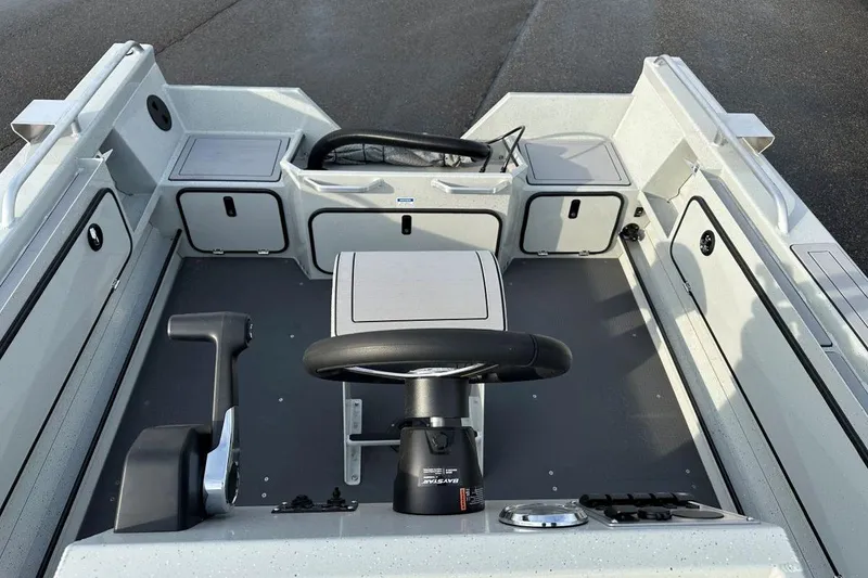 Slide: The Image of 2026 Weldcraft 200 Rebel Open CC boat interior with steering console and storage compartments. - 8
