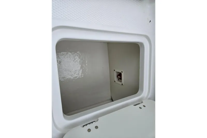 Slide: The Image of Storage compartment in 2025 Chaparral 21 SSi boat, featuring a clean, white interior. - 6
