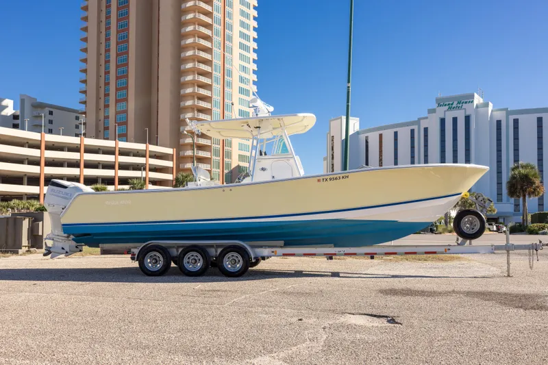 Slide: The Image of 2005 Regulator 32 Classic boat on trailer, parked near tall buildings. - 10