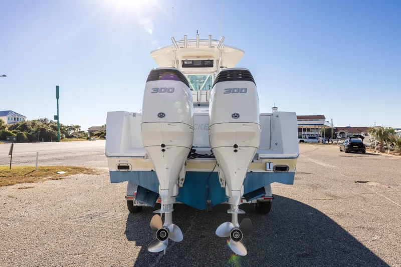 Slide: The Image of 2005 Regulator 32 Classic boat with twin 300 horsepower engines, parked under a clear sky. - 15