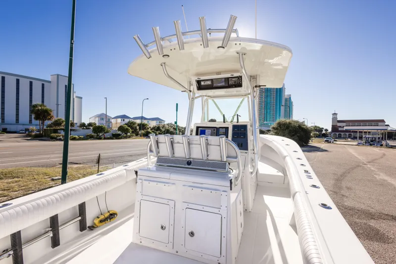 Slide: The Image of 2005 Regulator 32 Classic boat with center console, docked in a sunny urban setting. - 23