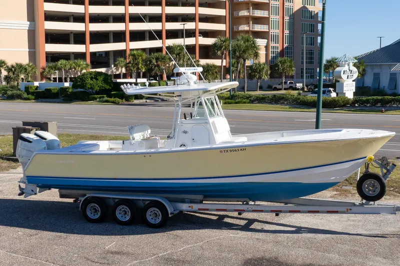 Slide: The Image of 2005 Regulator 32 Classic boat on trailer, parked near buildings and road. - 3