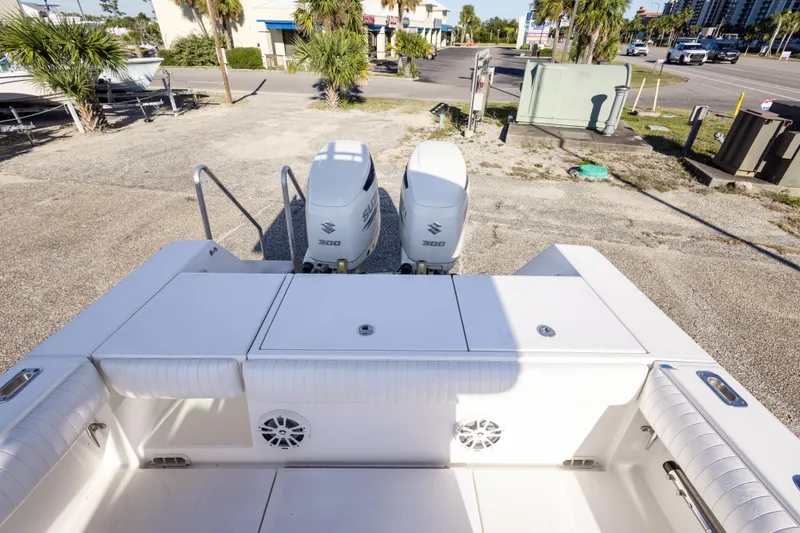 Slide: The Image of 2005 Regulator 32 Classic boat with twin Suzuki 300 engines, docked on land. - 30