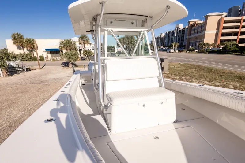Slide: The Image of 2005 Regulator 32 Classic boat with seating, docked near palm trees and buildings. - 32