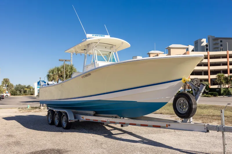 Slide: The Image of 2005 Regulator 32 Classic boat on trailer, parked outdoors under clear blue sky. - 7