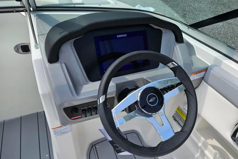Slide: The Image of 2025 Chaparral 23 SSi boat dashboard with steering wheel and digital display. - 8