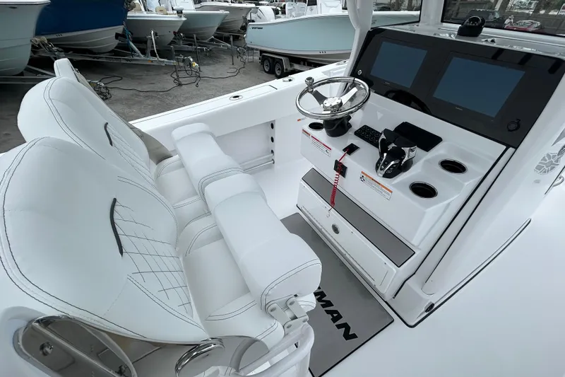 Slide: The Image of 2026 Sportsman Open 252 Center Console boat interior with steering wheel and dual screens. - 11